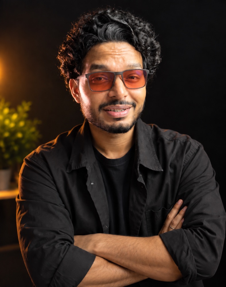 Nitin Nitro, arms crossed, smiling at the camera